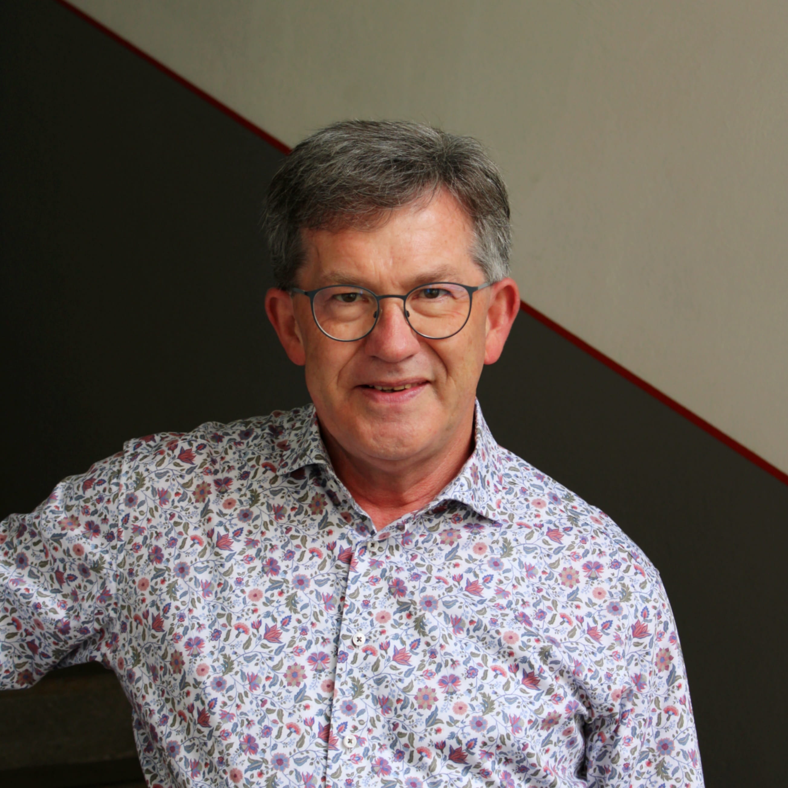 Dieter Schuh ist Mitarbeiter in der Buchhaltung. Er trägt ein helles Hemd und blickt lächelnd in die Kamera.