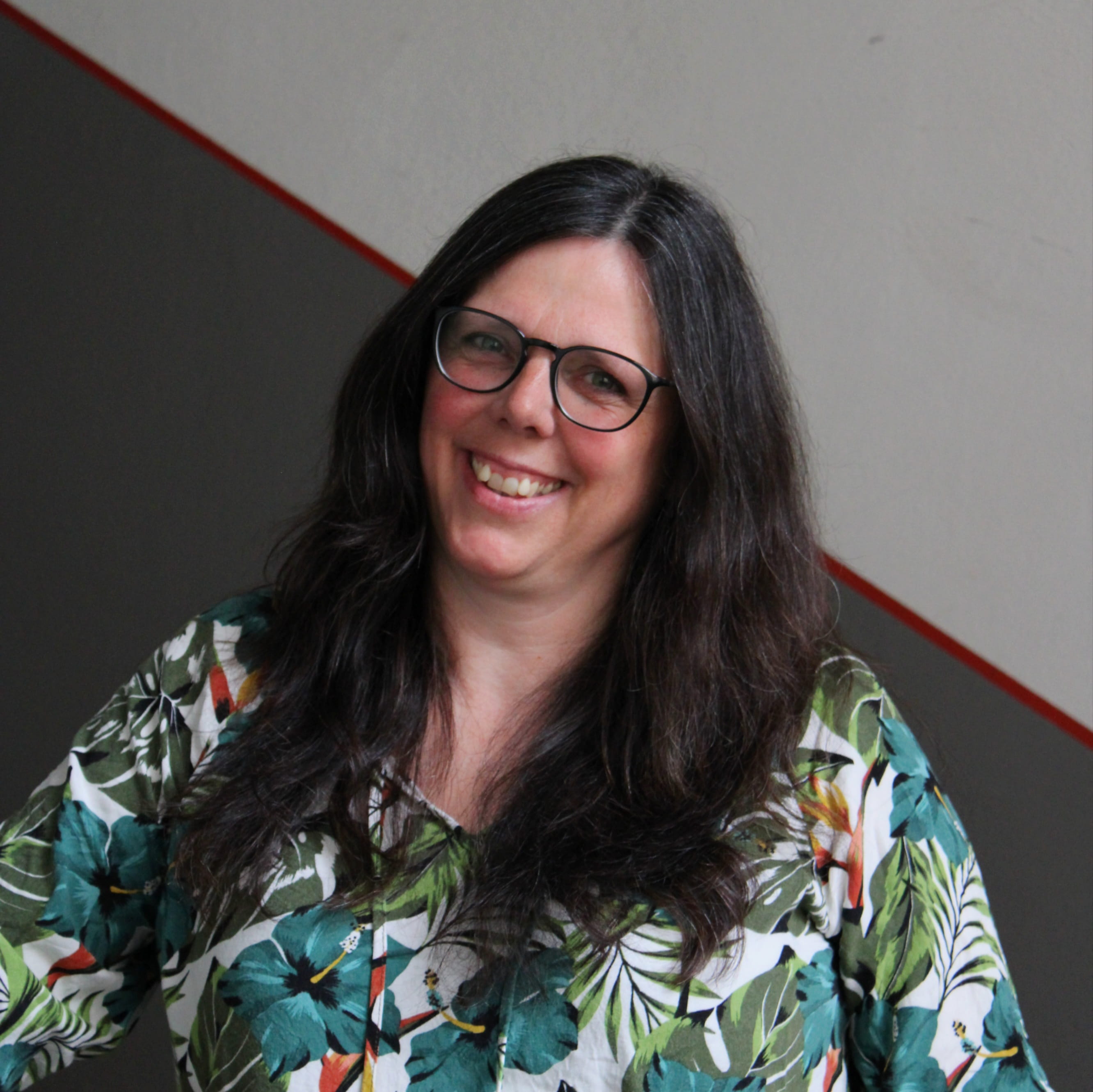 Lucia Schraudolf leitet das Buchungsbüro in Nürnberg. Sie trägt eine bunte Bluse und blickt lächelnd in die Kamera.