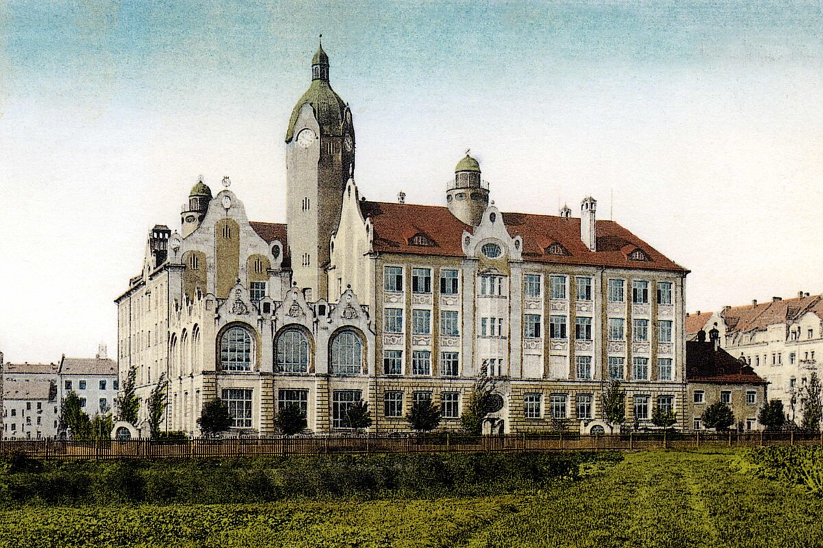 Kolorierte Postkarte mit einem herrschaftlichen weißen Gebäude mit großen Fenstern und Türmchen, davor eine grüne Wiese.