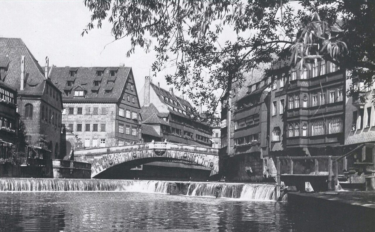 Schwarzweißaufnahme des Flusses Pegnitz mit Steinbrücke und historischen Fachwerkhäusern