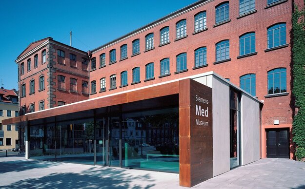 Ansicht des Siemens Med Museum, ein großes Backsteingebäude mit modernem Glasvorbau
