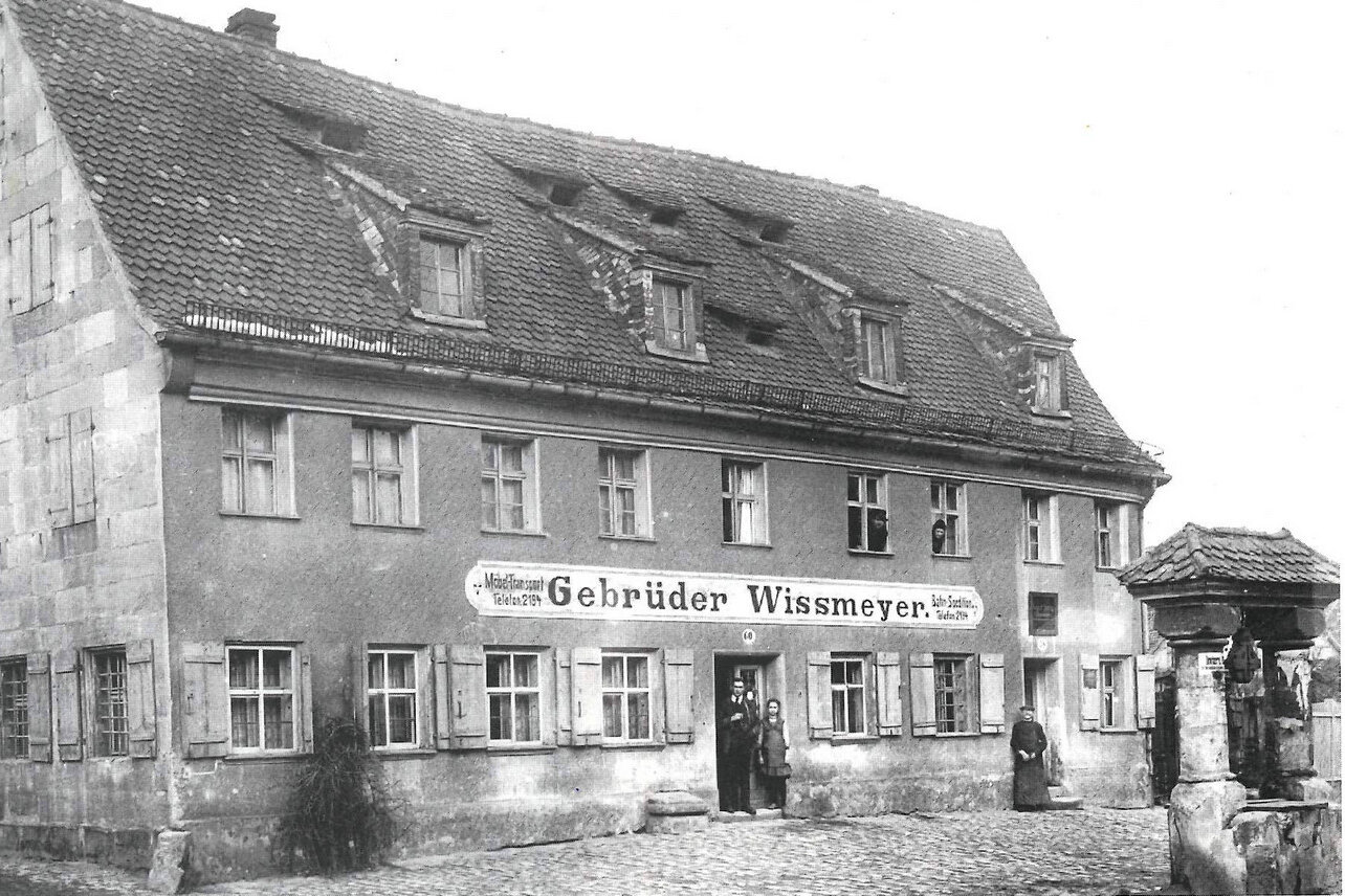 Schwarzweißaufnahme eines großen Gebäudes mit der Aufschrift 'Gebrüder Wissemeyer'