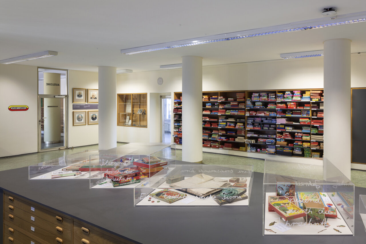Blick in den Ausstellungsraum des Deutschen Spielearchivs mit Vitrinen und Regalen