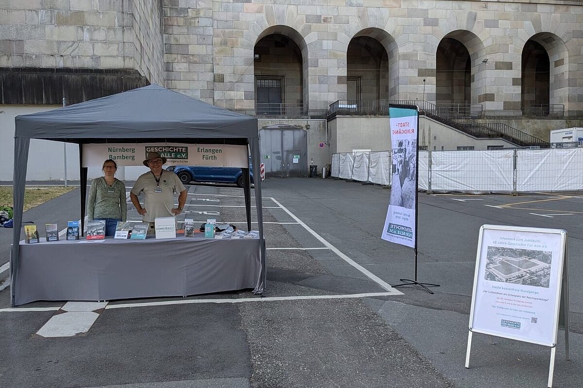 Dagmar Seck und Robert Dietz am Infostand, GFA 2025. Infostand von Geschichte Für Alle mit zwei Personen vor der Kongresshalle
