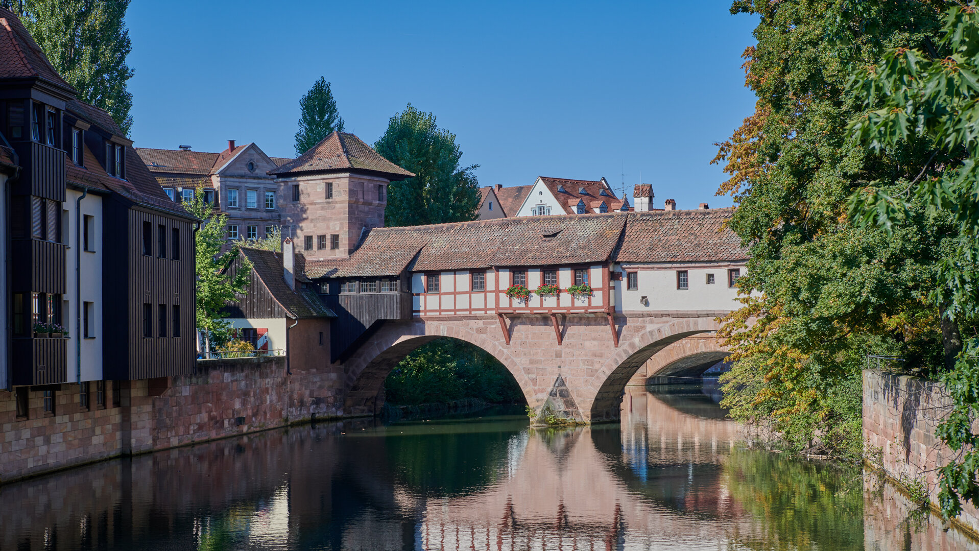 Das Henkerhaus mit Turm und Steinbrücke über der Pegnitz bei Sonnenschein