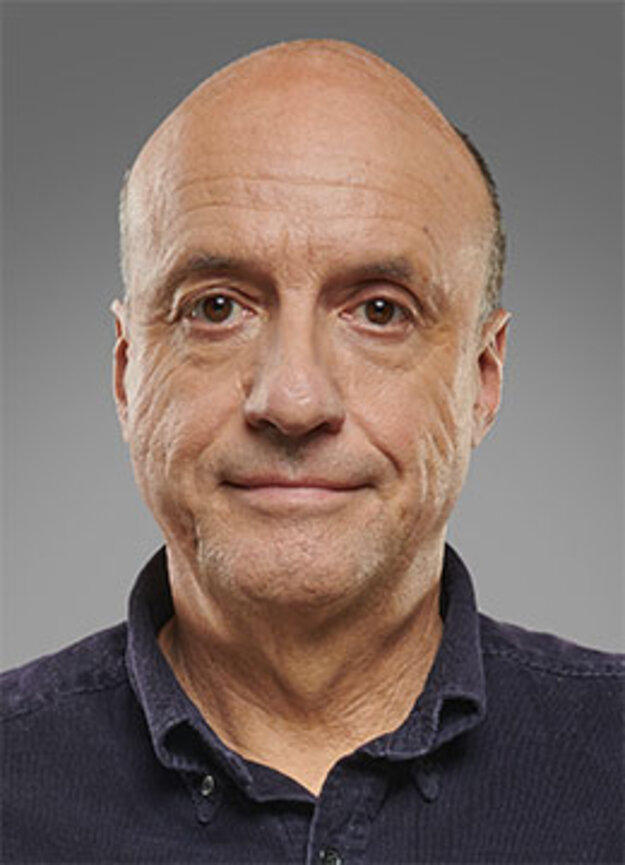 Freier Mitarbeiter Bernd Windsheimer, lächelnd vor grauem Hintergrund